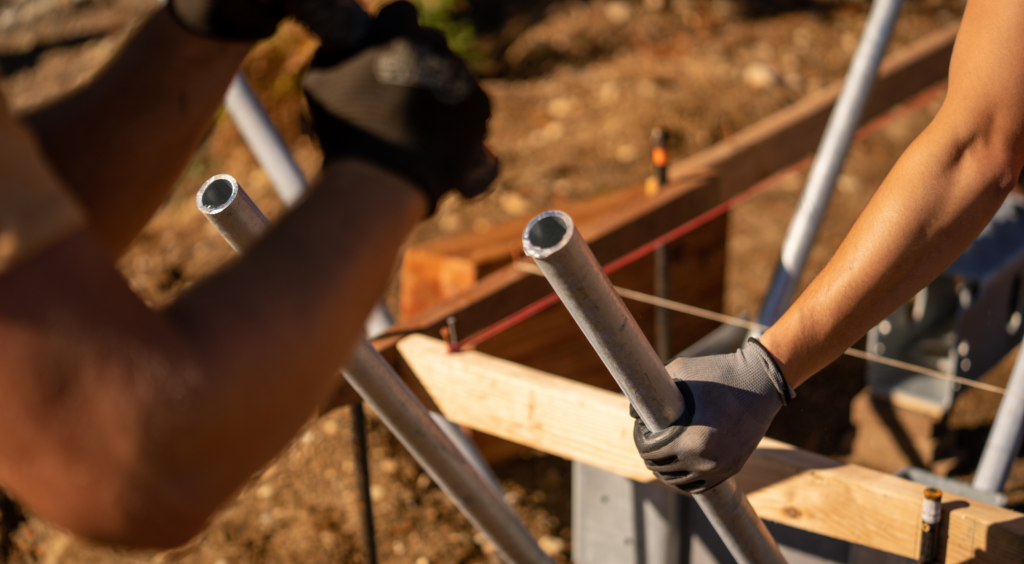 A close up of construction workers securing and inserting a Ground Frame solution.